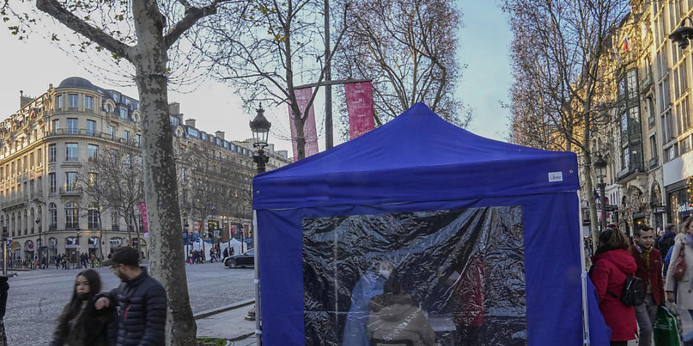 Ein medizinischer Angestellter nimmt Nasenabstriche an einer mobilen Teststation auf der Champs Elysees. Foto: Michel Euler/AP/dpa