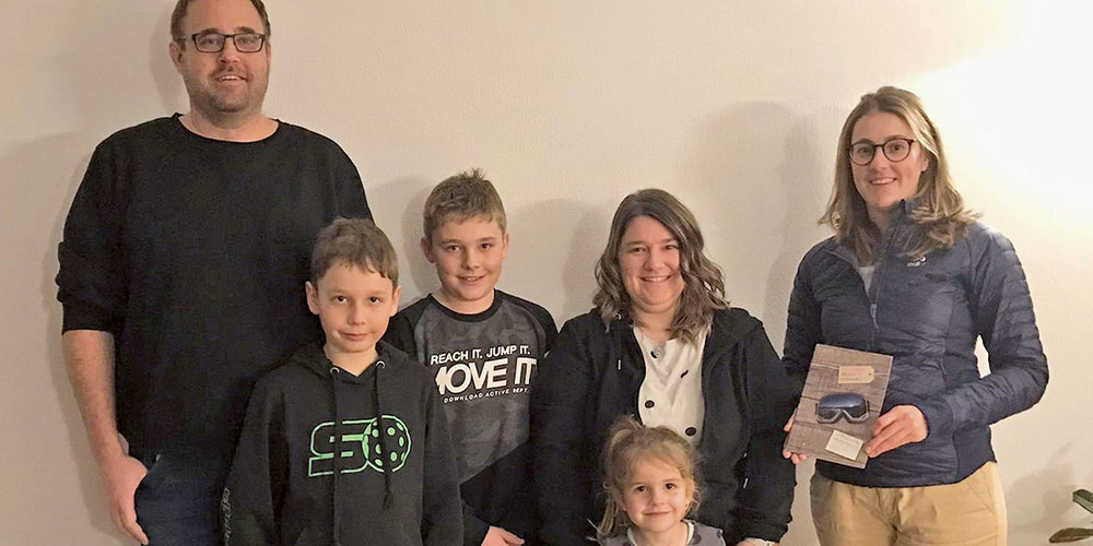 Angelika Luzi, Obfrau der Jugendmusik Jenaz (1. v. r.), übergibt der Siegerfamilie Schmid aus Jenaz den Gutschein für den Schlittelspass in den Fideriser Heubergen.