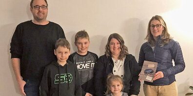 Angelika Luzi, Obfrau der Jugendmusik Jenaz (1. v. r.), übergibt der Siegerfamilie Schmid aus Jenaz den Gutschein für den Schlittelspass in den Fideriser Heubergen.