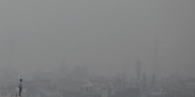 dpatopbilder - Ein Mann steht auf dem Sims eines Gebäudes in Neu Delhi, während Smog über der ganzen Stadt liegt. In der indischen Hauptstadt wurden wegen starken Smogs die Schulen von Freitag an bis auf weiteres geschlossen. Das Höchste Gericht d...
