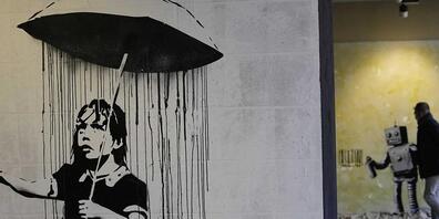 «The Umbrella girl», eine Reproduktion eines Wandgemäldes des britischen Künstlers Banksy. Foto: Luca Bruno/AP/dpa - ACHTUNG: Nur zur redaktionellen Verwendung und nur mit vollständiger Nennung des vorstehenden Credits