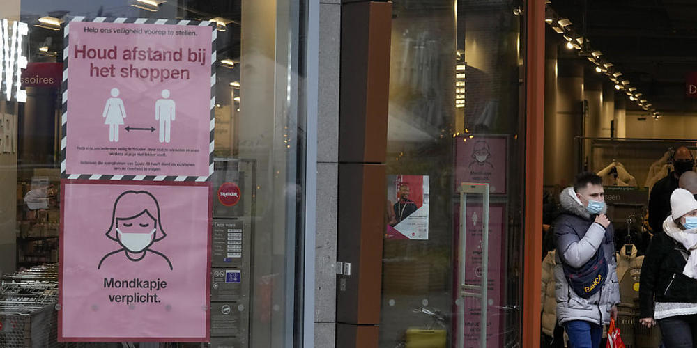 Hinweisschilder sind im Schaufenster eines Geschäftes angebracht, die Kunden auf die Corona-Maßnahmen hinweisen sollen. Für zunächst drei Wochen gilt in den Niederlanden ein abendlicher Lockdown ab 17:00 Uhr, bei dem Geschäfte, Kulturstätten, Gast...