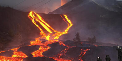 Soldaten der spanischen Armee stehen auf einem Hügel vor einem Lavastrom auf La Palma. Foto: Emilio Morenatti/AP/dpa