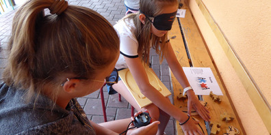 Die Schülerinnen und Schüler tasten sich durch den Erlebnisgang. 