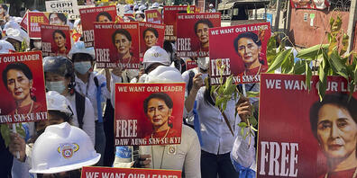 ARCHIV - Demonstranten halten Plakate mit dem Konterfei von Aung San Suu Kyi, ehemalige Regierungschefin von Myanmar, während einer Anti-Putsch-Demonstration. In Myanmar hat ein Gericht die entmachtete Regierungschefin Aung San Suu Kyi zu vier Jah...