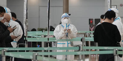 Ein Beamter in Schutzausrüstung wartet auf Reisende in der Abflughalle des internationalen Flughafens Incheon in Südkorea. Foto: Ahn Young-Joon/AP/dpa
