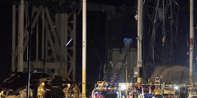 Ersthelfer arbeiten vor einem Amazon-Vertriebszentrum, nachdem es durch einen Tornado schwer beschädigt wurde. Rettungskräfte hätten eine Anzahl der Eingeschlossenen aus dem Gebäude herausholen können. Unklar sei aber, wie viele noch innen verharr...