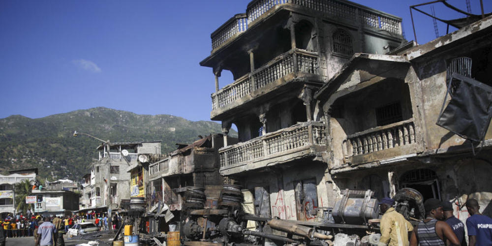 dpatopbilder - Feuerwehrleute stehen neben den Überresten eines mit Benzin beladenen Lastwagens, der in Brand geriet und explodierte. Bei der Explosion eines Tanklasters sind in Haiti Dutzende Menschen ums Leben gekommen. Der Premierminister Ariel...