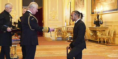 dpatopbilder - Lewis Hamilton (r) aus Großbritannien von Team Mercedes wird von Charles, Prinz von Wales, auf Schloss Windsor in Windsor zum Ritter geschlagen. Foto: Dominic Lipinski/PA/AP/dpa