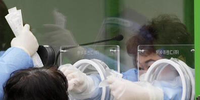 Eine medizinische Angestellte nimmt in Seoul bei einer Frau eine Probe für einen Coronatest. Foto: Lee Jin-Man/AP/dpa