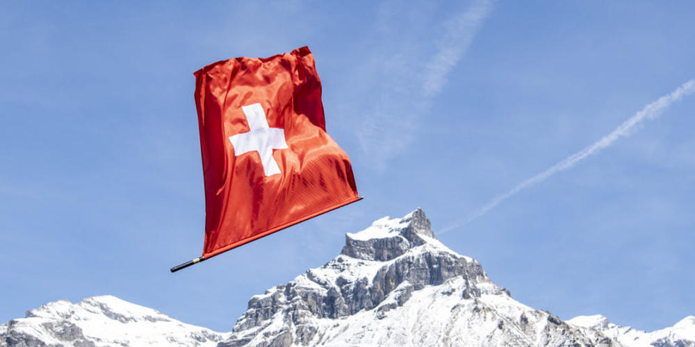 Eine Schweizerfahne eines Fahnenschwingers schwingt durch die Luft vor dem Hausberg von Engelberg, dem Hahnen. (Archivbild)