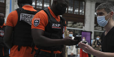 ARCHIV - Sicherheitsbeamte kontrollieren in Lyon die Gesundheitspässe der Reisenden. Seit der Einführung der Nachweispflicht sind die Behörden in Frankreich auf 182.000 gefälschte Dokumente gestoßen. Foto: Adrienne Surprenant/AP/dpa