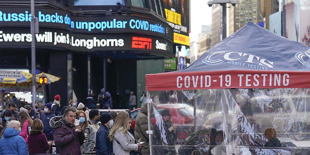 Menschen warten in einer Schlange vor einem Covid-Testzentrum am Times Square. Foto: Seth Wenig/AP/dpa
