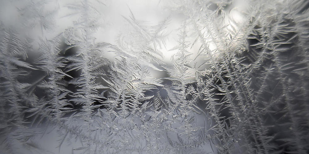 Eisblumen auf einem Fenster: Am Dienstagmorgen war es in Teilen der Schweiz bitterkalt. (Themenbild)