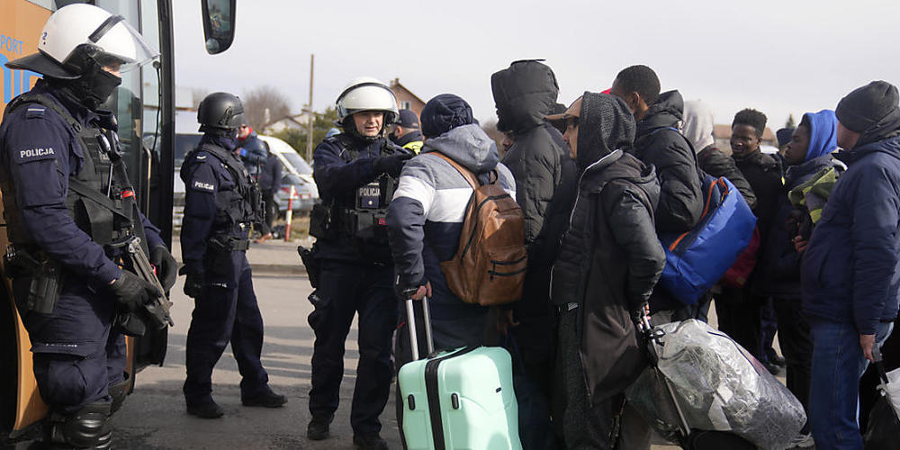 Menschen, die vor dem Krieg in der Ukraine geflohen sind, warten am polnischen Grenzübergang auf einen Bus. Foto: Markus Schreiber/AP/dpa
