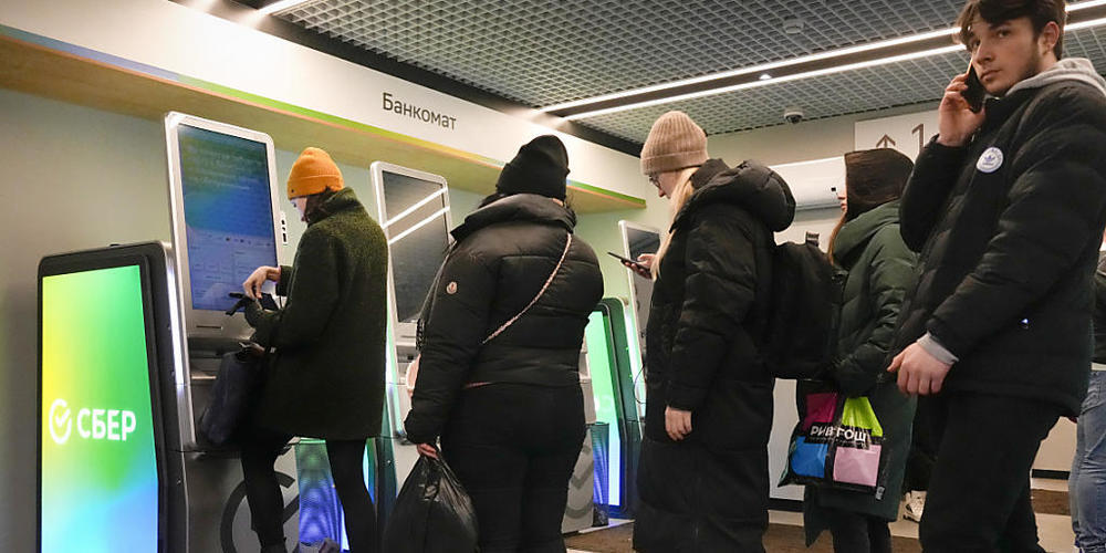 Menschen in St. Petersburg heben Geld von ihren Konten bei der von Sanktionen betroffenen Sberbank ab. Die Schweizer Tochtergesellschaft der russischen Grossbank meldet, bei ihr gehe die Arbeit weiter.