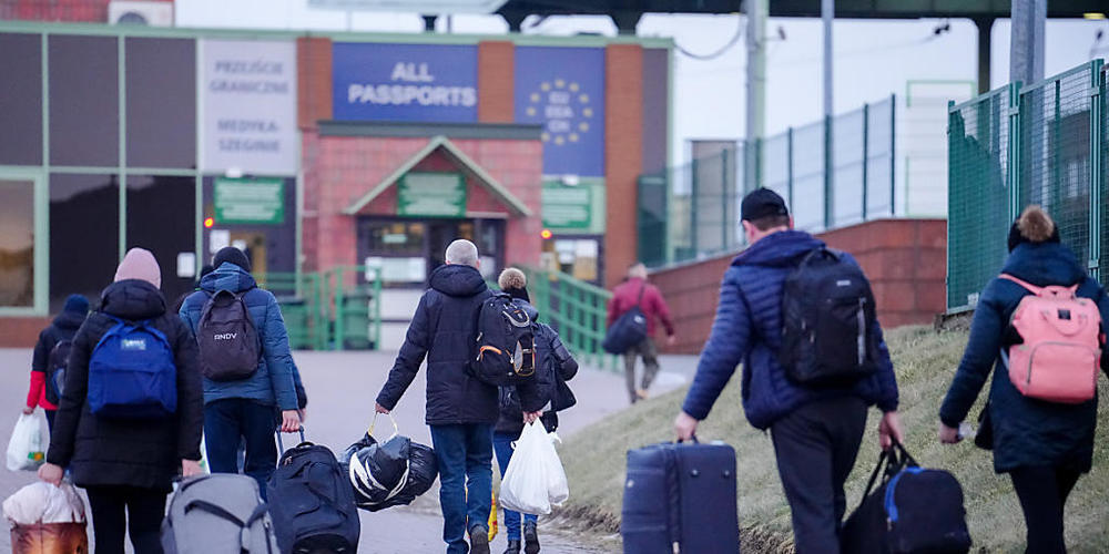 Einige Menschen passieren am Abend die ukrainsch-polnische Grenze in Medyka in Richtung Ukraine. 