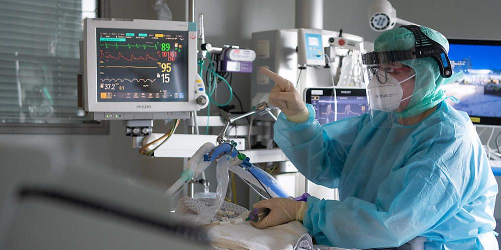 Eine Intensiv-Pflegerin versorgt einen schwer an Corona erkrankten Patienten auf der Intensivstation des Klinikums in Fulda. Rund die Hälfte der künstlich beatmeten Patienten stirbt.