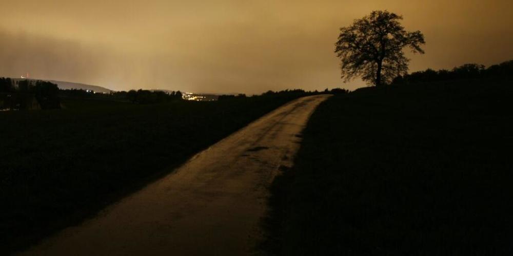 Die Lichter der Stadt Zürich erhellen den Nachthimmel über Tagelswangen.