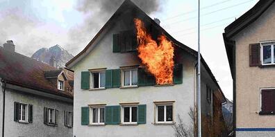 Flammen schlagen aus einem Fenster im zweiten Obergeschoss des Wohnhauses. Dort dürfte der Brand ausgebrochen sein.