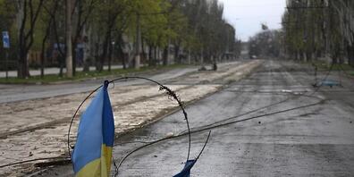 In Mariupol liegt eine ukrainische Flagge an einem Draht auf dem Boden. Die russischen Streitkräfte haben in der umkämpften ukrainischen Hafenstadt am Dienstag eine einseitige Feuerpause verkündet. Foto: Alexei Alexandrov/AP/dpa