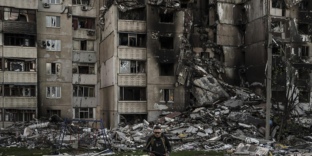 Ein ukrainischer Soldat geht inmitten der Trümmer eines Gebäudes, das durch mehrfachen russischen Beschuss in der Nähe einer Frontlinie schwer beschädigt wurde. Foto: Felipe Dana/AP/dpa