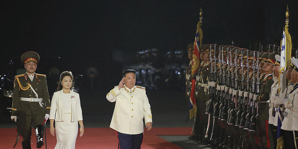 HANDOUT - Auf diesem von der nordkoreanischen Regierung zur Verfügung gestellten Foto schreitet Kim Jong-un, Machthaber von Nordkorea, gemeinsam mit seiner Frau Ri Sol Ju die Ehrengarde während einer Militärparade anlässlich des 90. Jahrestages de...