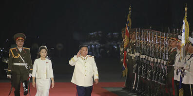 HANDOUT - Auf diesem von der nordkoreanischen Regierung zur Verfügung gestellten Foto schreitet Kim Jong-un, Machthaber von Nordkorea, gemeinsam mit seiner Frau Ri Sol Ju die Ehrengarde während einer Militärparade anlässlich des 90. Jahrestages de...