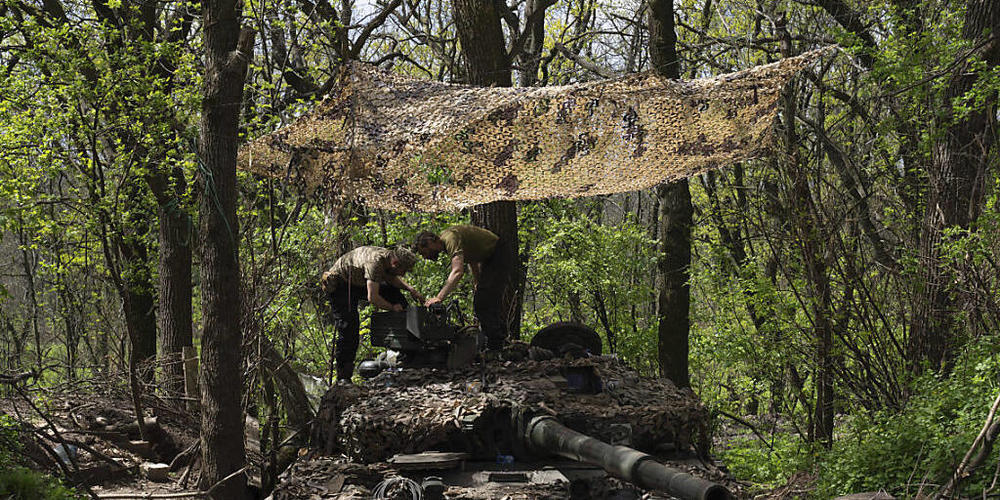 Ukrainische Soldaten installieren während Reparaturarbeiten ein Maschinengewehr auf einem Panzer nach Kämpfen gegen russische Truppen in der Region Donezk. Foto: Evgeniy Maloletka/AP/dpa