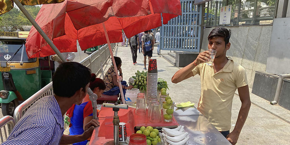 Ein Mann löscht seinen Durst bei einem Straßenverkäufer vor einer U-Bahn-Station. Indien und Pakistan leiden unter einer frühen Hitzewelle. Indien hat bereits den heißesten März seit Beginn der Wetteraufzeichnungen vor 122 Jahren erlebt. Foto: Sho...