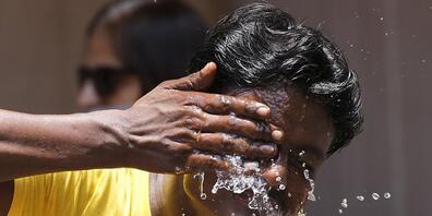 Ein Mann spritzt sich an einem extrem heißen Tag auf einem Marktplatz in Mumbai Wasser ins Gesicht. Indien und Pakistan leiden unter einer frühen Hitzewelle. Indien hat bereits den heißesten März seit Beginn der Wetteraufzeichnungen vor 122 Jahren...