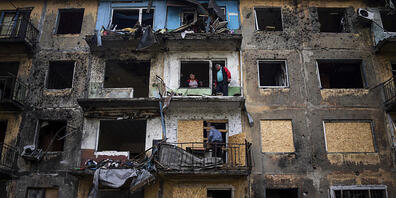 Anwohner schließen die Fenster eines Wohnhauses mit Sperrholz nach russischem Beschuss in Dobropillja in der Region Donezk in der Ostukraine. Foto: Evgeniy Maloletka/AP/dpa