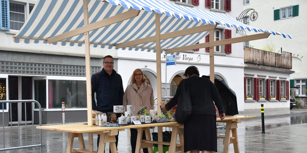 Organisatorisch in regem Austausch: Antoinette Cathomas (Marktkommission) und Dani Giger (Gemeinderat) werden durch einen der neuen Marktstände vor dem Regen geschützt.