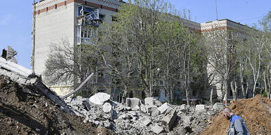Ein Arbeiter steht neben dem Krater einer Explosion neben einem Wohnhaus, das durch nächtlichen Beschuss in Kramatorsk beschädigt wurde. Foto: Andriy Andriyenko/AP/dpa