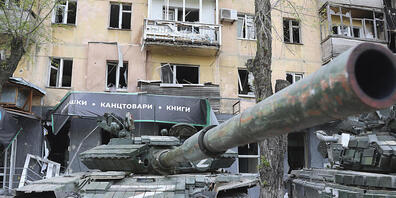 Panzer der Miliz der Volksrepublik Donezk stehen neben einem beschädigten Wohnhaus in Mariupol, einem Gebiet unter der Regierung der Volksrepublik Donezk im Osten der Ukraine. Foto: Alexei Alexandrov/AP/dpa