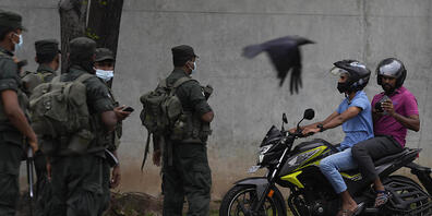 Soldaten der Armee von Sri Lanka besetzen einen Kontrollpunkt während der Ausgangssperre, die einen Tag nach Zusammenstößen zwischen Regierungsanhängern und Regierungsgegnern in Colombo, Sri Lanka, verhängt worden ist. Foto: Eranga Jayawardena/AP/dpa