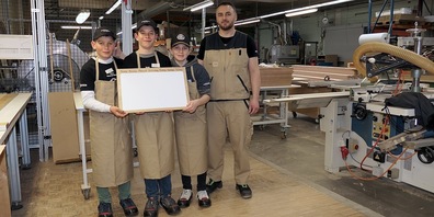 v.l. die Diepoldsauer Fünftklässler Andreas, Romeo und Davey mit Schreiner Enis, der sie bei der Anfertigung des Magnetboards anleitete.