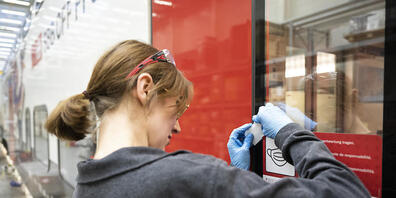 Eine SBB-Mitarbeiterin entfernt Aufkleber, die auf die Maskenpflicht im Zug aufmerksam machen. Seit Freitag müssen in der Schweiz im öffentlichen Verkehr wegen der Coronavirus-Pandemie keine Masken mehr getragen werden.