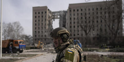 Ein ukrainischer Soldat sichert nach einem russischen Angriff den Bereich neben dem Gebäude der Gebietsverwaltung. Foto: Petros Giannakouris/AP/dpa