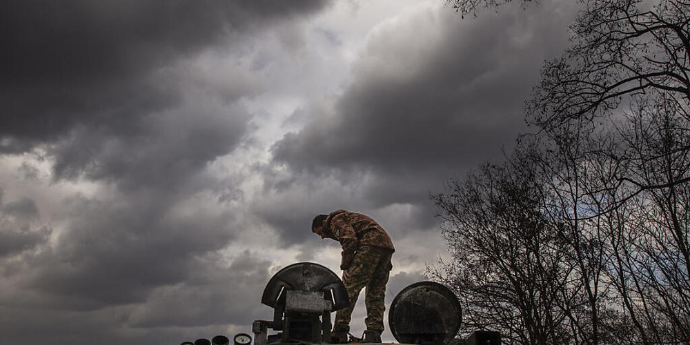 Ein ukrainischer Soldat untersucht an einer Straße zwischen Okhtyrka und Trostyanets einen russischen Panzer. Foto: Daniel Carde/ZUMA Press Wire/dpa