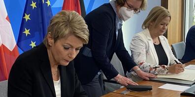 Bundesrätin Karin Keller-Sutter (links) unterzeichnet gemeinsam mit der deutschen Innenministerin Nancy Faeser (rechts) das revidierte Polizeiabkommen zwischen den beiden Ländern.