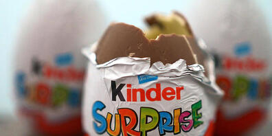Drei britische Varianten der Kinder-Überraschungseier liegen auf einem Tisch. Hat Ferrero nun auch in Australien zahlreiche Kinder-Produkte zurückgerufen. Diese seien möglicherweise mit Salmonellen belastet, teilte die für Lebensmittelsicherheit z...
