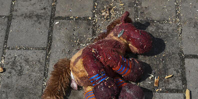 Ein blutverschmiertes Plüschpferd liegt auf dem Bahnsteig des von Raketen getroffenen Bahnhofs von Kramatorsk.