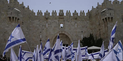 dpatopbilder - Israelis schwenken Nationalflaggen vor dem Damaskustor außerhalb der Altstadt Jerusalems. Bei einem umstrittenen Flaggenmarsch ist es auf dem Tempelberg am Sonntag zu Konfrontationen gekommen. Foto: Mahmoud Illean/AP/dpa