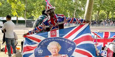 Joseph Afrane schwenkt eine Fahne mit einem Bild der Queen entlang der Pall Mall im Zentrum der Hauptstadt. Foto: Sophie Wingate/PA Wire/dpa