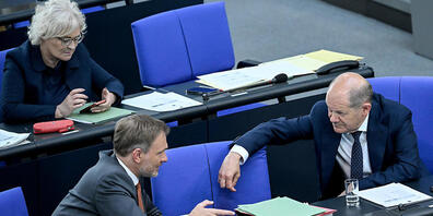 Christine Lambrecht (SPD), Bundesverteidigungsministern, Christian Lindner (FDP), Bundesfinanzminister, und Bundeskanzler Olaf Scholz (SPD - r), sitzen im Bundestag in der Regierungsbank. Mit einer Änderung des Grundgesetzes soll vom Parlament ein...