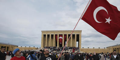 Ein Mann schwenkt eine türkische Nationalfahne, während Tausende das Mausoleum von Mustafa Kemal Atatürk besuchen. Die Vereinten Nationen verwenden auf Wunsch der Türkei ab sofort «Türkiye» anstelle der bisherigen englischen Landesbezeichnung «Tur...