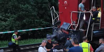 Polizisten stehen am Ort des Zugunglücks. Beim Zusammenstoß eines Personenzuges mit einer Lokomotive sind in der Slowakei viele Menschen verletzt worden. Foto: Erika ·urëov·/TASR/dpa