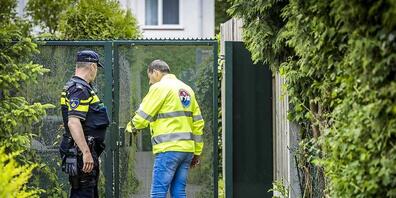 Polizisten stehen an einem Tor bei der Wiederaufnahme der Suche nach einem vermissten Jungen aus Kerkrade. Am Samstag wurde die Leiche des neunjährigen Gino gefunden. Das teilte die Polizei in Kerkrade mit. Foto: Marcel Van Hoorn/ANP/dpa