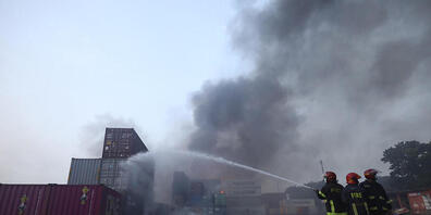 Feuerwehrleute bei den Löscharbeiten eines Feuers im BM Inland Container Depot. Foto: Uncredited/AP/dpa